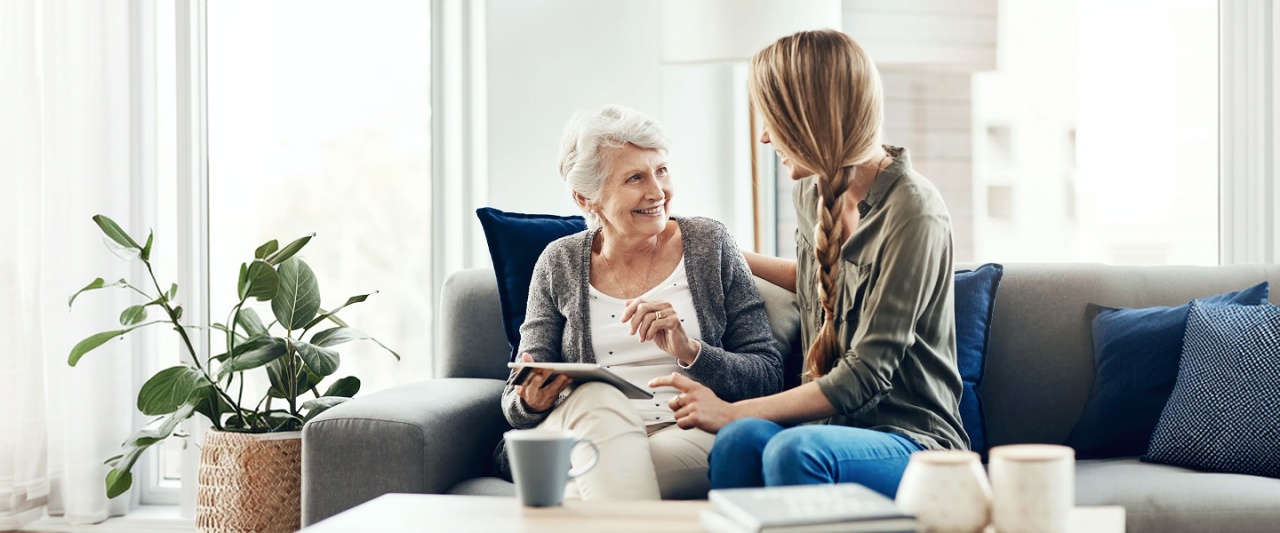 a woman sitting beside an elderly woman offering comfort
