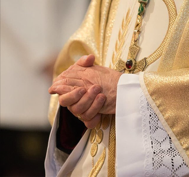 a close-up of a pastor's hands gently clasped together