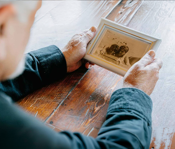old man looking at a photo frame