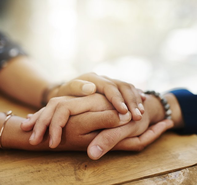 hands clasped in support and comfort